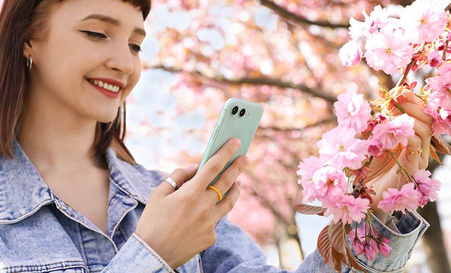 Woman taking a picture of cherry blossoms